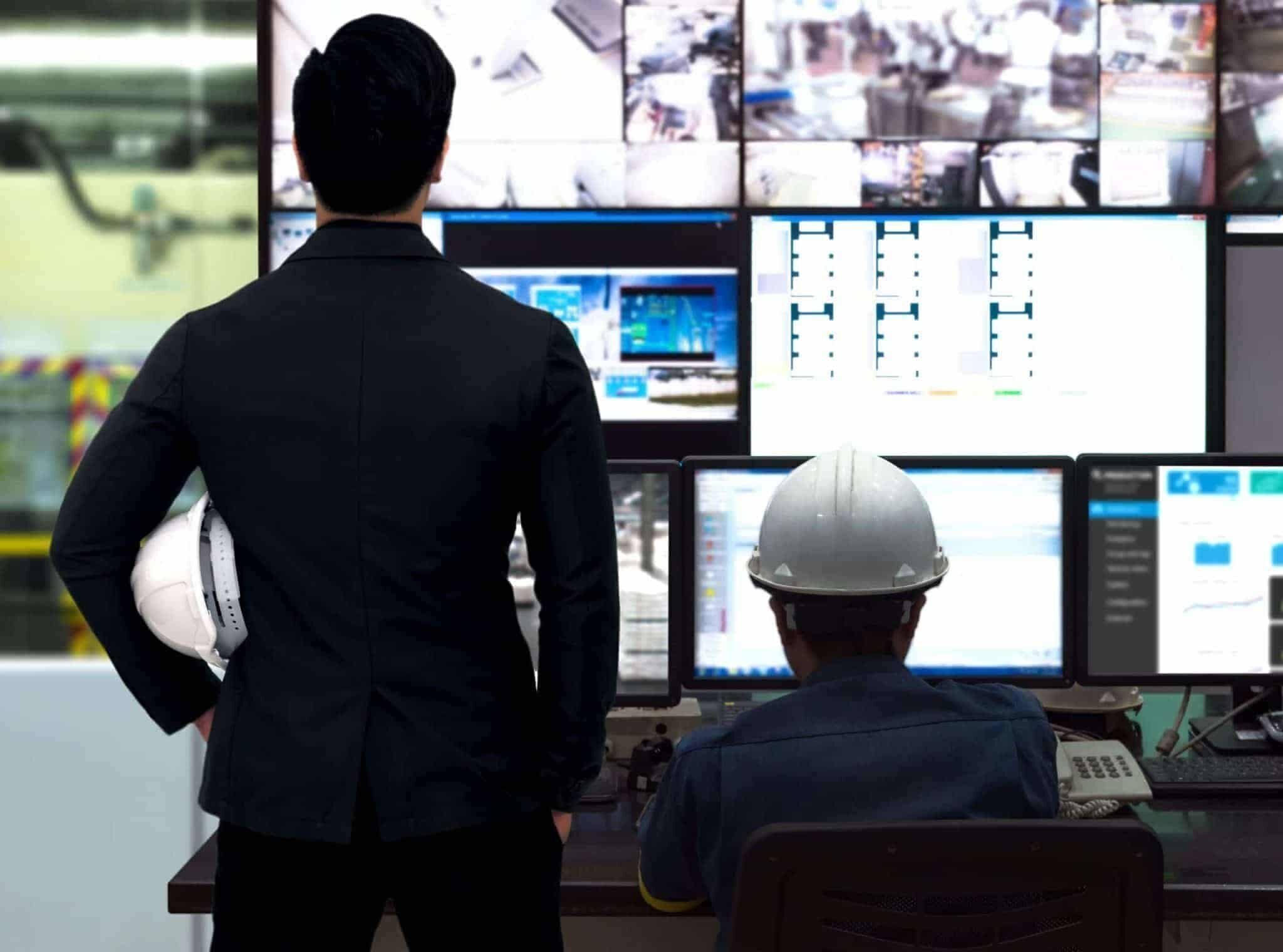 Process Control room and Industrial Automation in industry 4.0 technology trend concept. Engineer and director manager monitoring real time work automation machine process in smart factory.